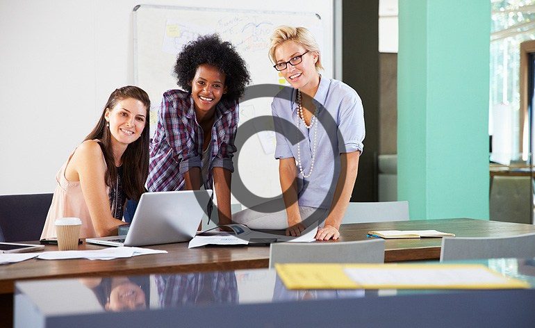 Three women working in a modern office.