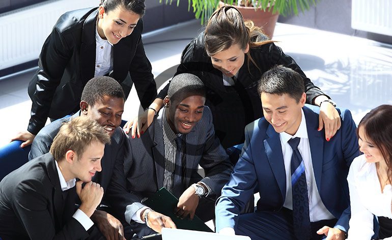 Group of young professionals looking at document.