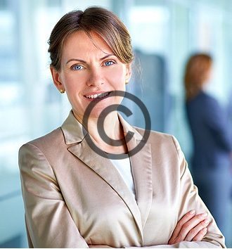 Smiling businesswoman with arms crossed in office.